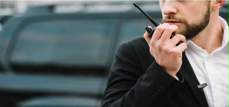 security guard notifying other guards during a mobile escort via a walky talky