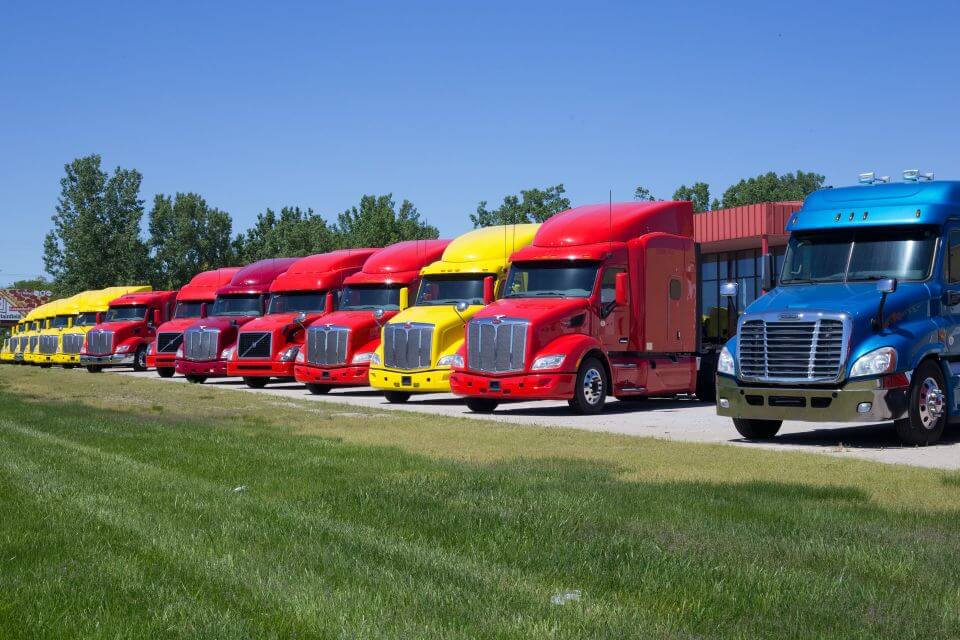 line of semitrucks resting at a trucking terminal