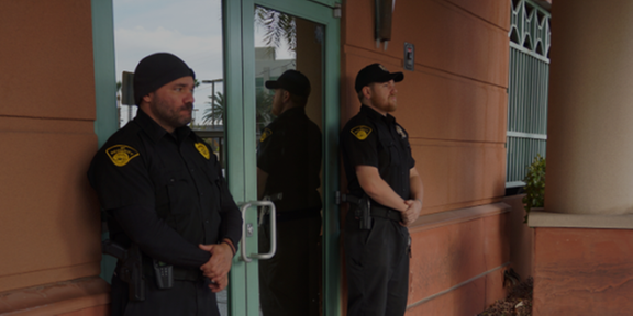 two armed guards outside of a client location